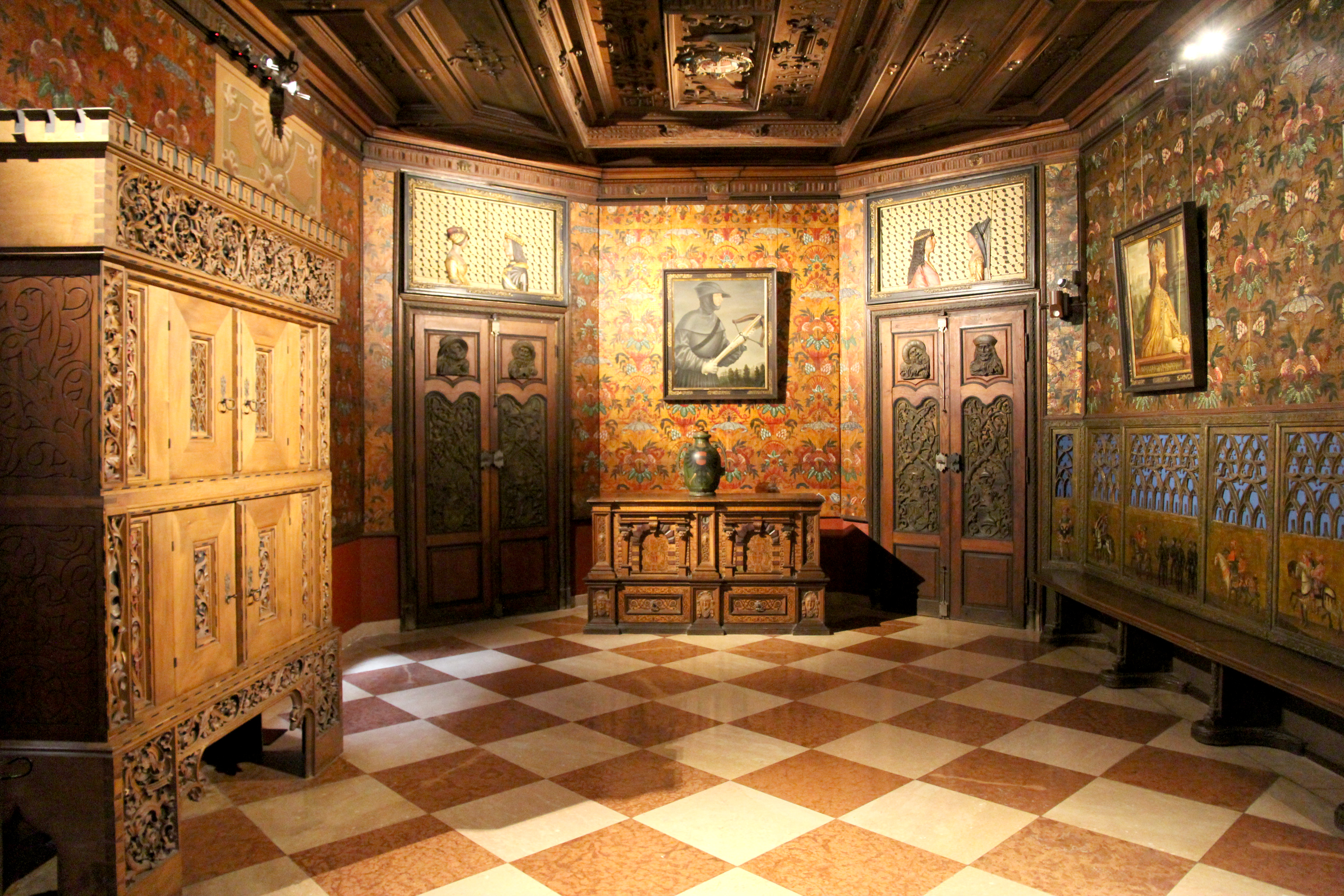 Ausstellungsraum im Franzensburg Museum. Zu sehen sind zwei an den Wänden hängende Porträt Gemälde in einem Zimmer, in dem jedes Detail, inklusive Decke und Möbel, aufwendig verziert ist.