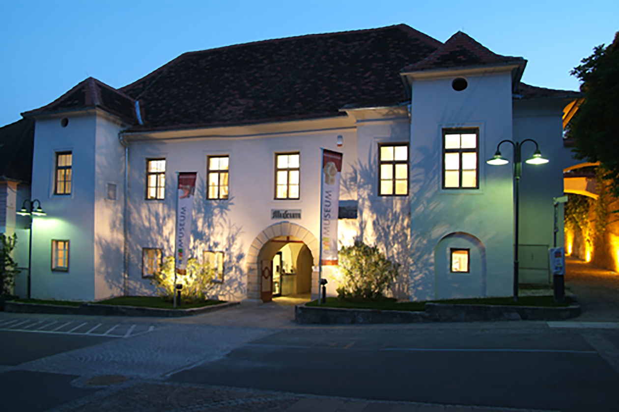 Beleuchtetes Museum Hartberg nach Abenddämmerung.
