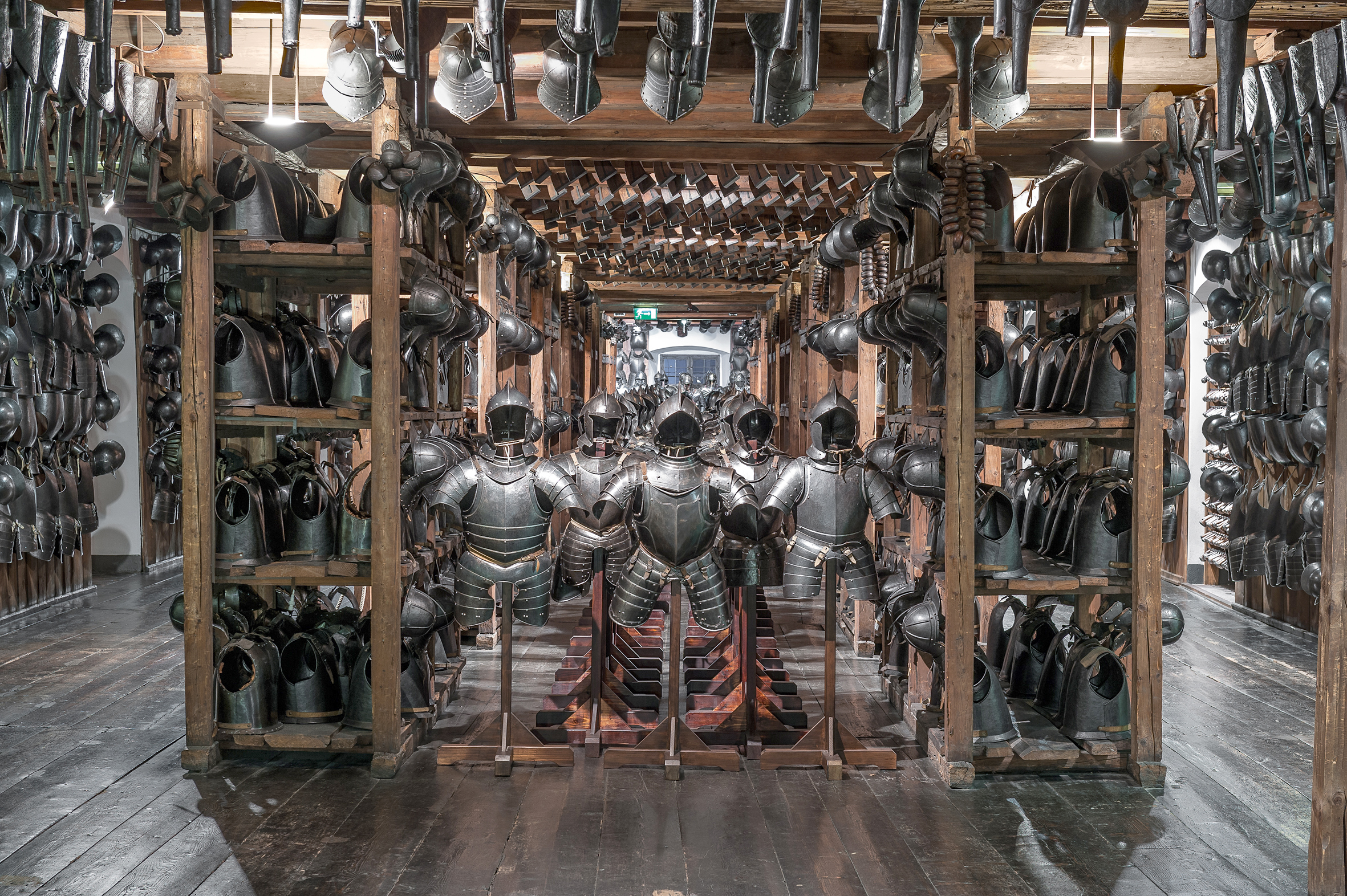 Foto eines Ausstellungsraums im Landeszeughaus. Zu sehen sind reihenweise historische Metallrüstungen.