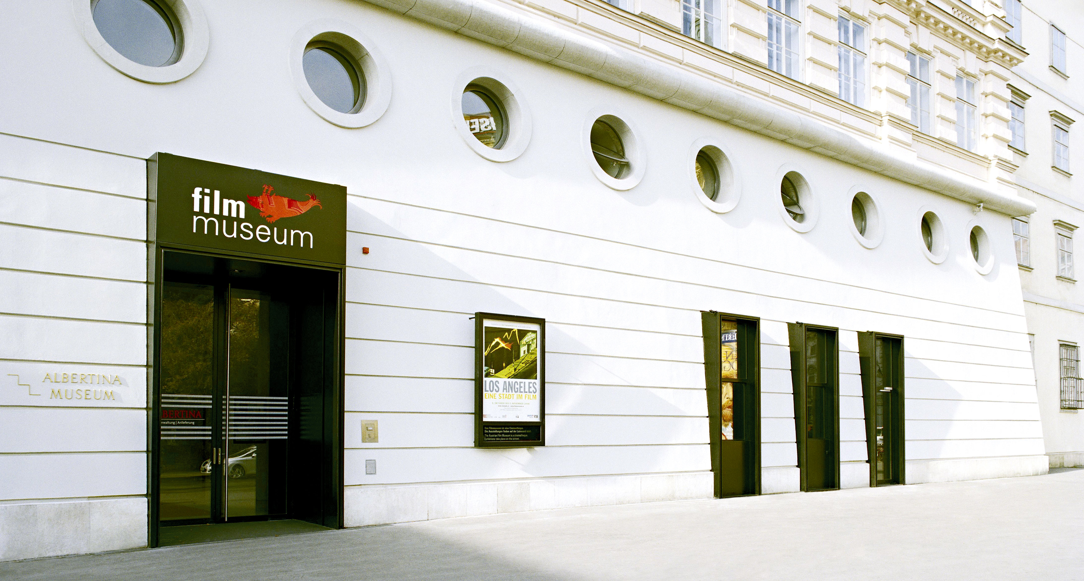 Foto des Eingangs zum Filmmuseum sowie der Fassade an sonnigem Tag.
