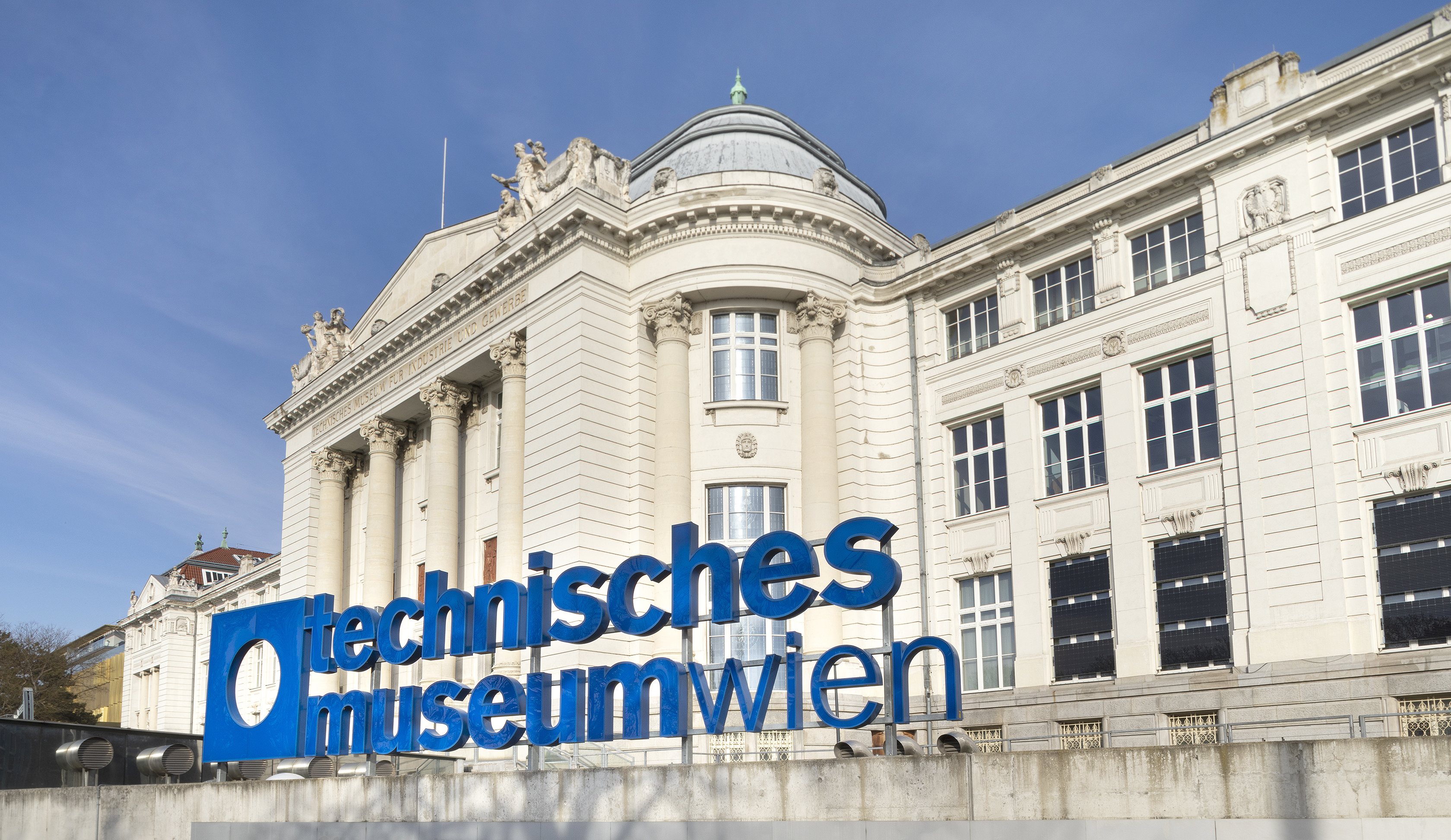 Foto des Technischen Museums Wien mit blauem Logo und Schriftzug vor dem Gebäude.