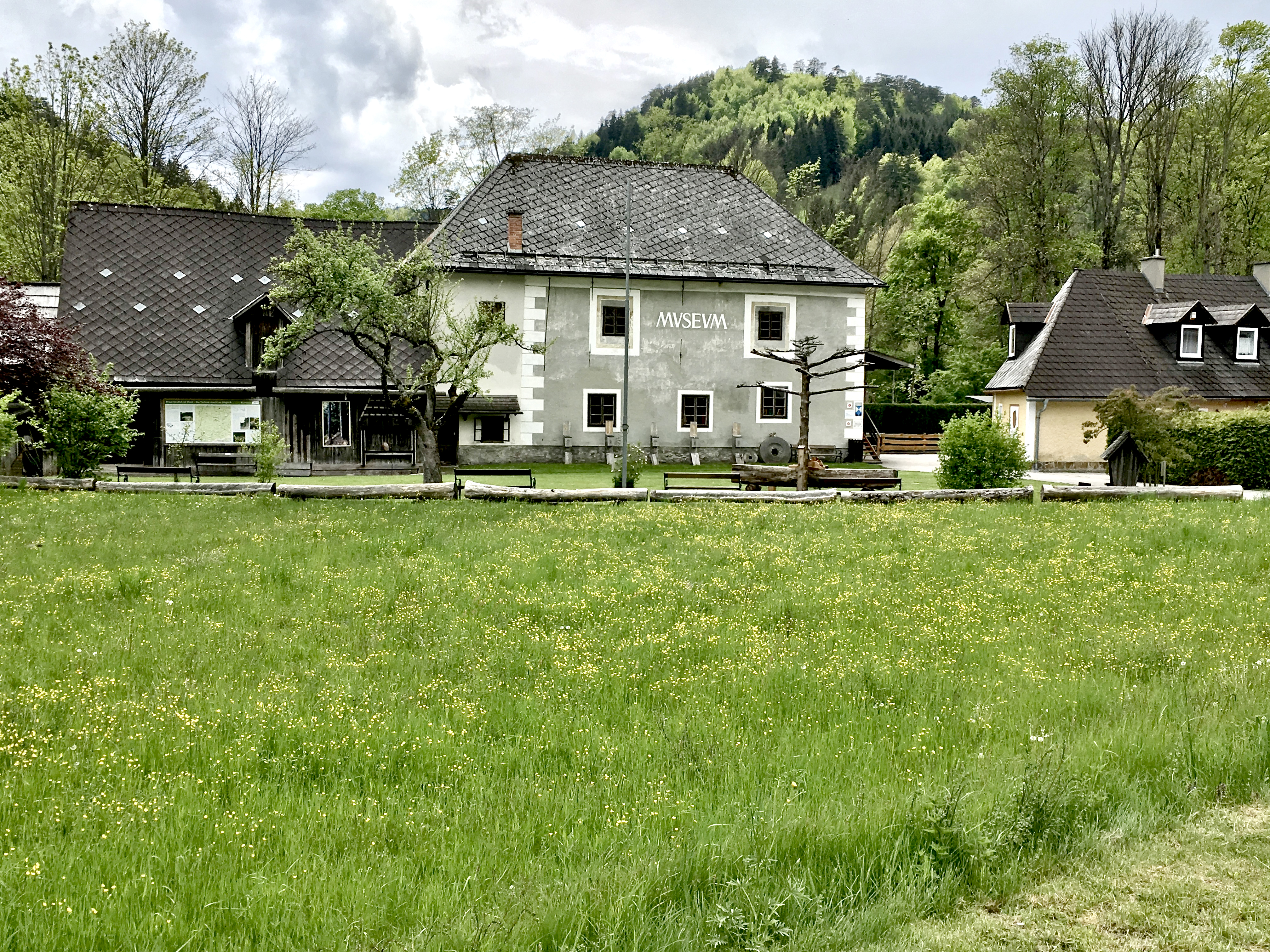 Foto des in grüner, bewaldeter Hügellandschaft stehenden Waldbauernmuseums
Gutenstein bei leicht bewölktem Himmel.